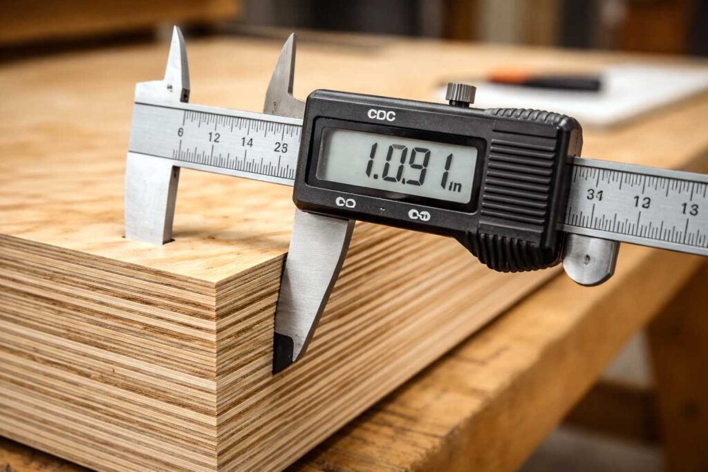 calipers measuring actual plywood thickness