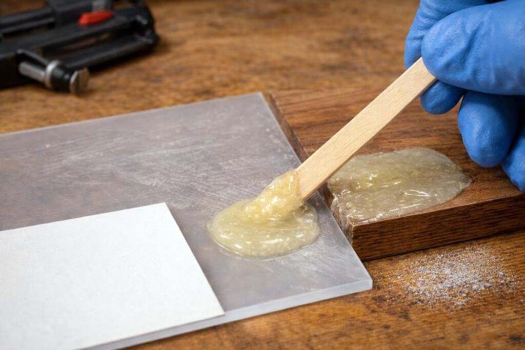 mixed epoxy spread on wood and plastic for strong bond