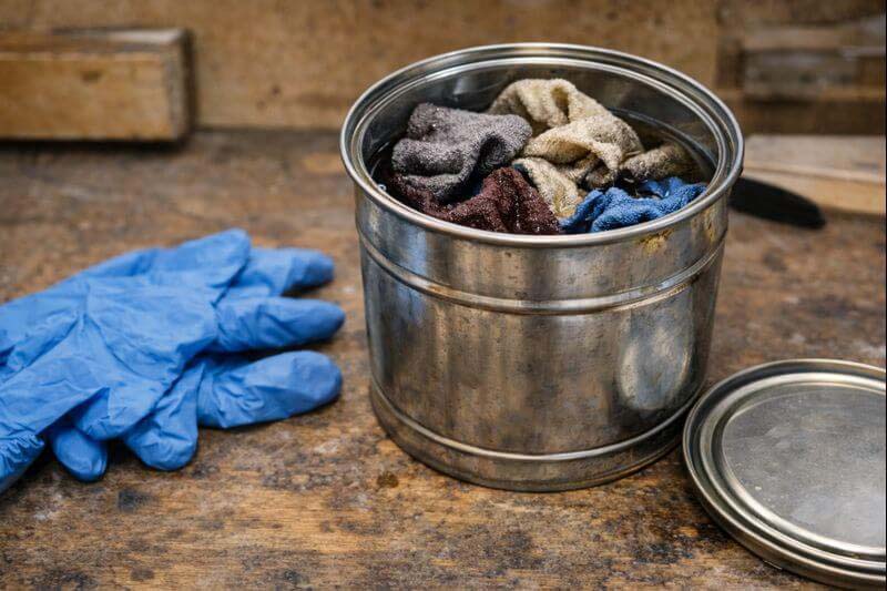 metal can with water for safe storage of solvent soaked rags