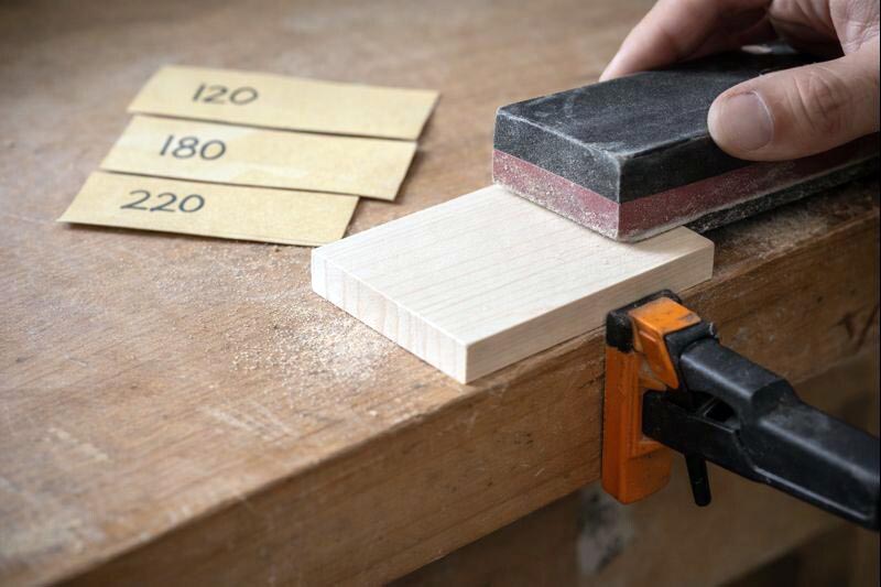 sanding a small wooden sign blank flat before painting