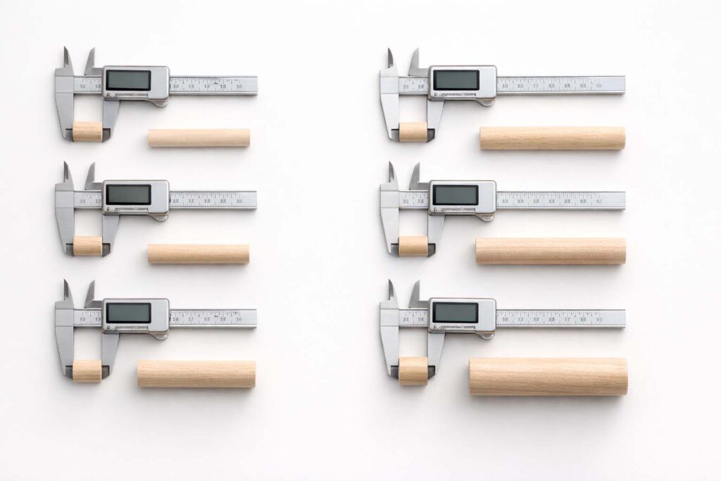 common dowel diameters arranged with calipers on a white background