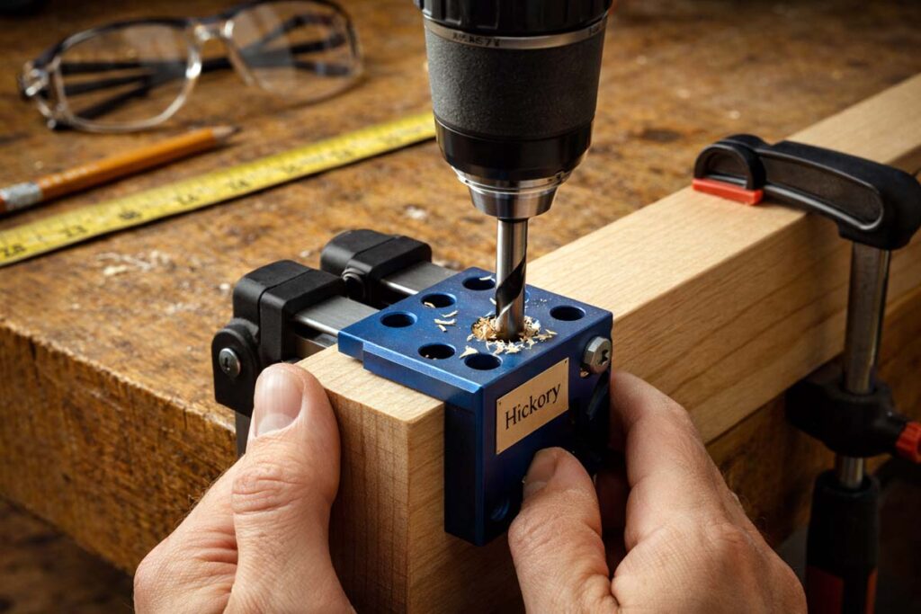 hands drilling dowel holes with doweling jig and brad point bit